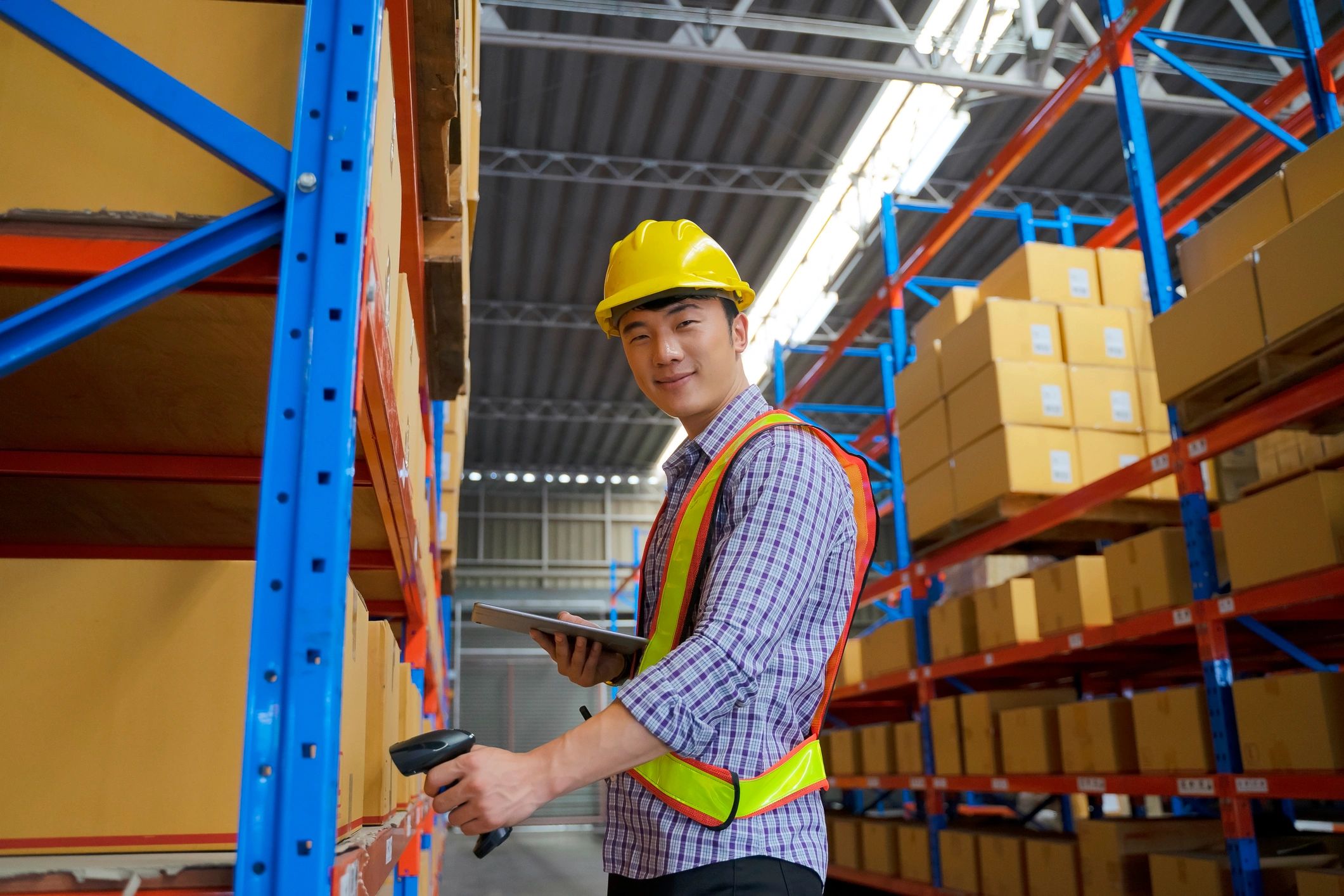 Logistics professional using a tablet in a warehouse workspace