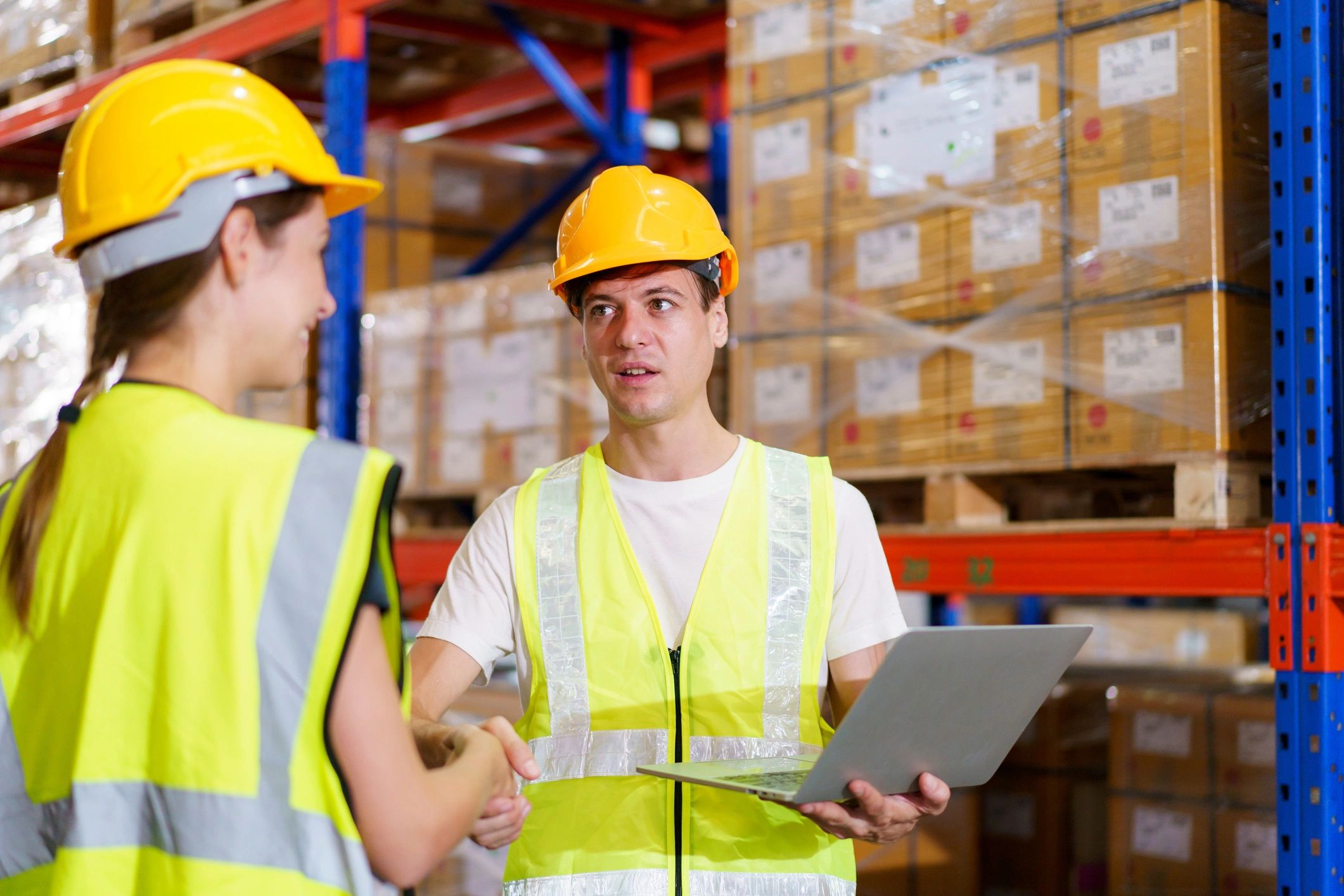Two logistics professionals meeting in a warehouse environment