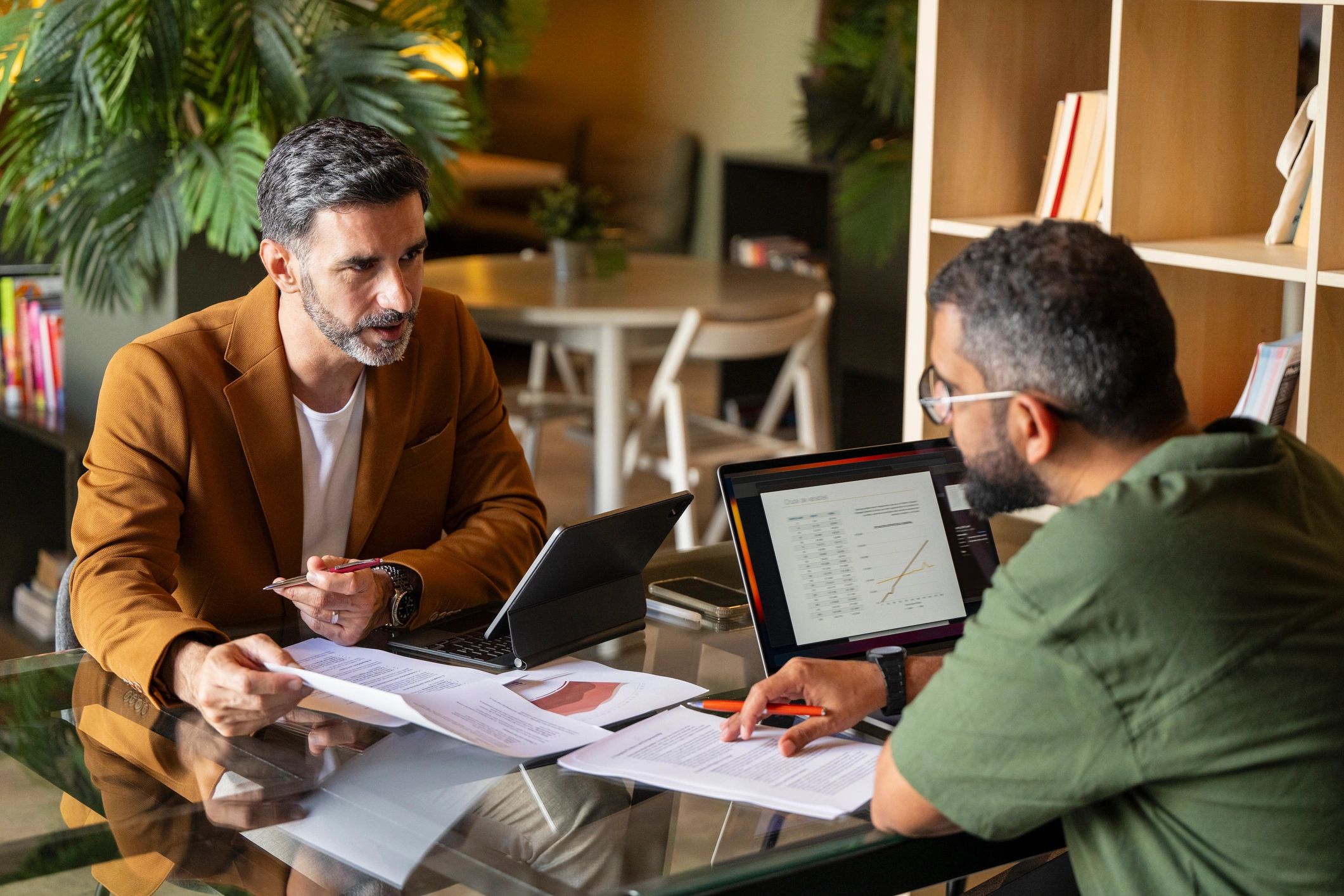 Advisor and client reviewing business paperwork at a table